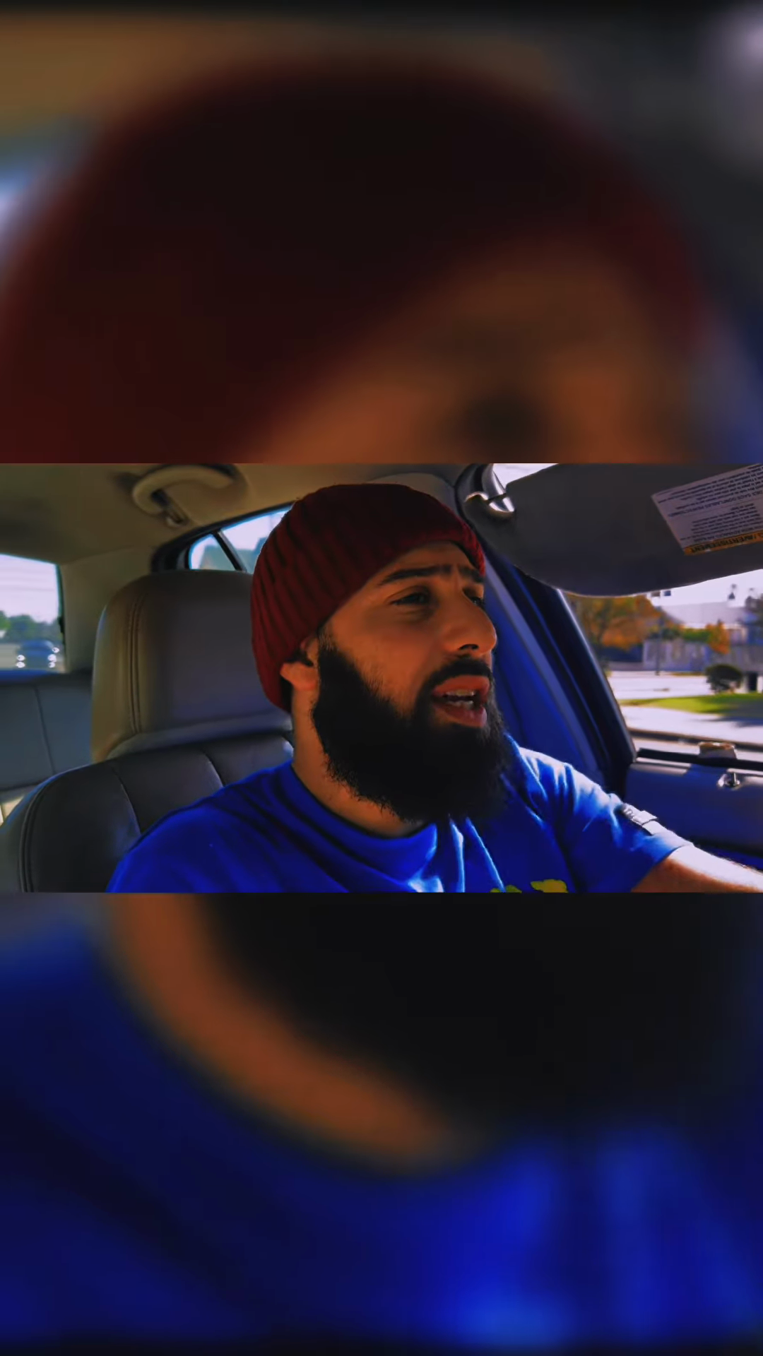 Matt Nye performing in his red beanie and blue shirt
